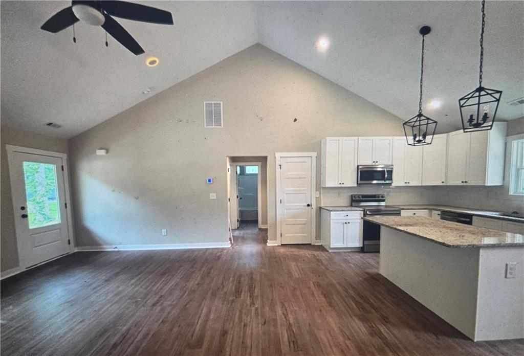 816 Forrest Avenue Rockmart, GA 30153 - Photo 2 of 18 a kitchen with stainless steel appliances granite countertop a sink a stove a refrigerator and island with wooden floor