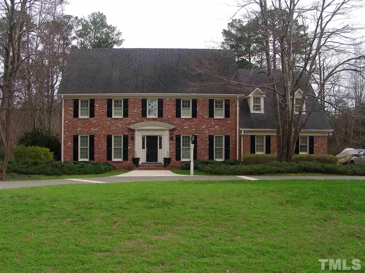 6904 North Ridge Drive Raleigh, NC 27615 - Photo 1 of 6 a front view of a brick house with a yard