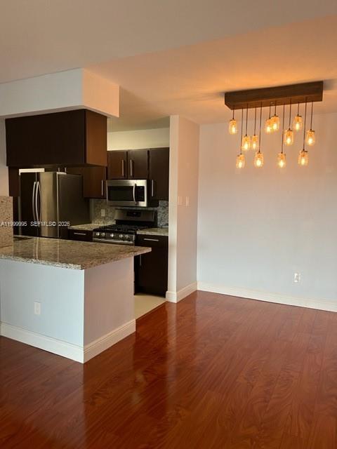 15330 Southwest 106th Terrace, Unit 918 Miami, FL 33196 - Photo 5 of 11 a kitchen with granite countertop a refrigerator and a stove top oven