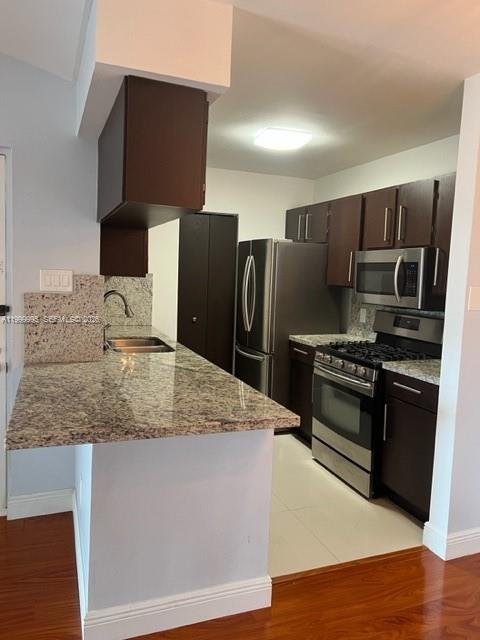 15330 Southwest 106th Terrace, Unit 918 Miami, FL 33196 - Photo 6 of 11 a kitchen with kitchen island a counter space a sink and stainless steel appliances
