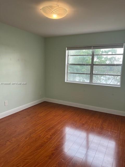 15330 Southwest 106th Terrace, Unit 918 Miami, FL 33196 - Photo 10 of 11 an empty room with wooden floor and windows