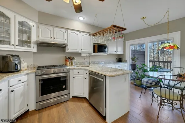 a kitchen with cabinets stainless steel appliances and a sink