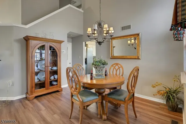 a dining room with furniture a chandelier and wooden floor