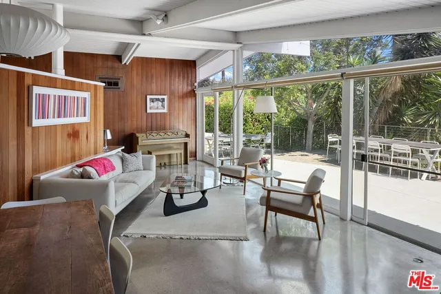a living room with furniture and a floor to ceiling window