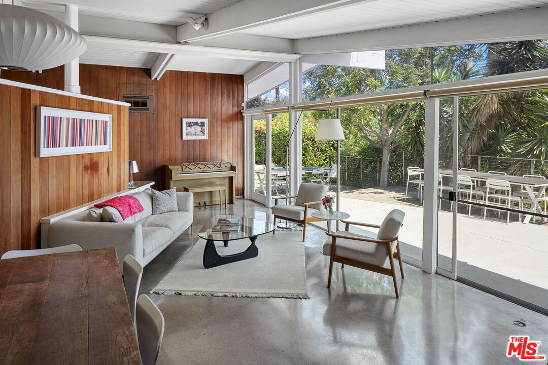 a living room with furniture and a floor to ceiling window