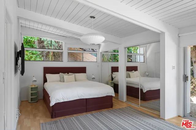 a bedroom with a bed and a flat screen tv