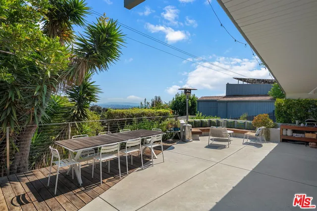 a view of a roof deck with table and chairs with wooden floor and fence