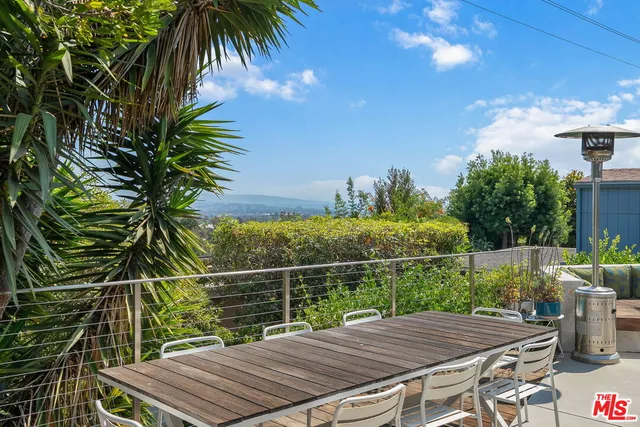 a view of a balcony with chairs and a potted plant