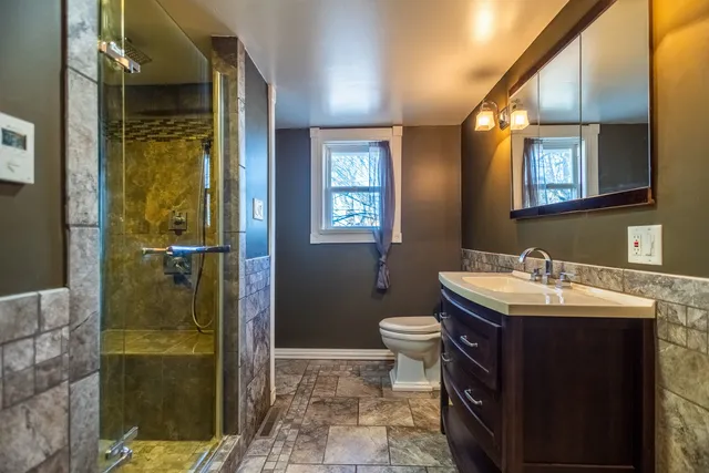 a bathroom with a sink a toilet and shower