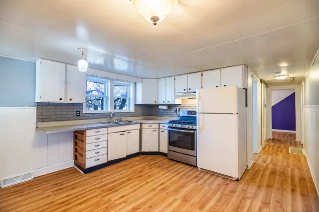 a kitchen with granite countertop appliances a sink and a refrigerator