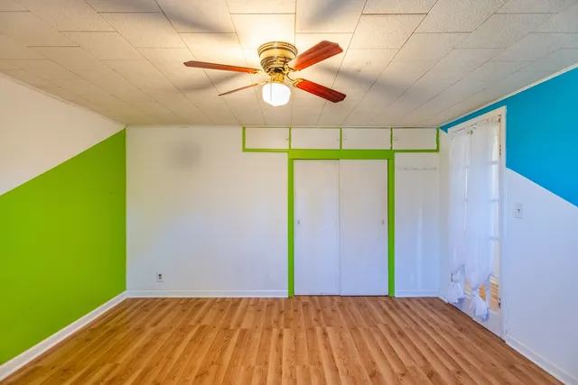 a view of a room with a ceiling fan and a window
