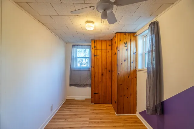 a view of a hallway with wooden floor and chandelier