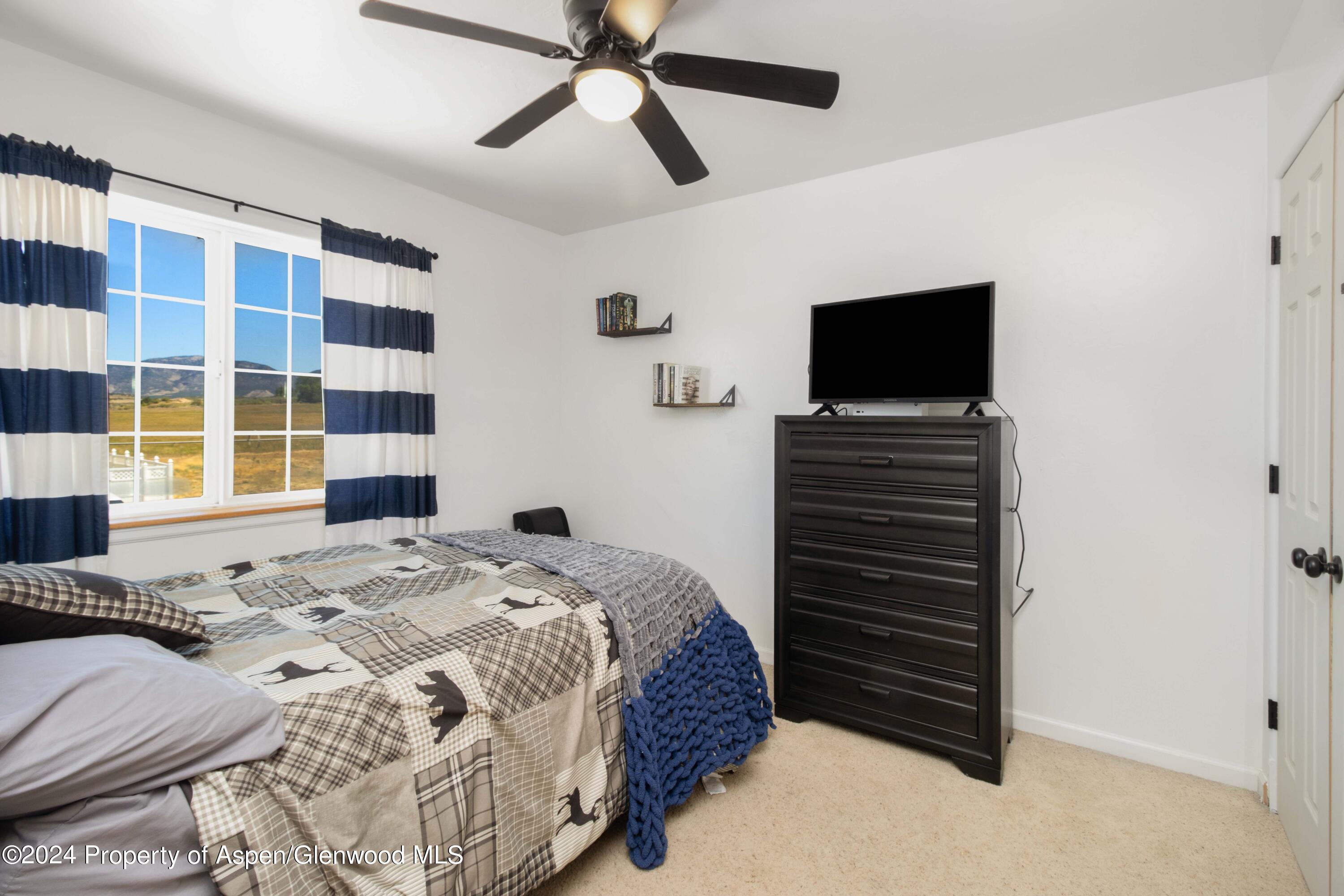 783 East 19th Street Rifle, CO 81650 - Photo 17 of 21 a bedroom with a bed and a flat screen tv