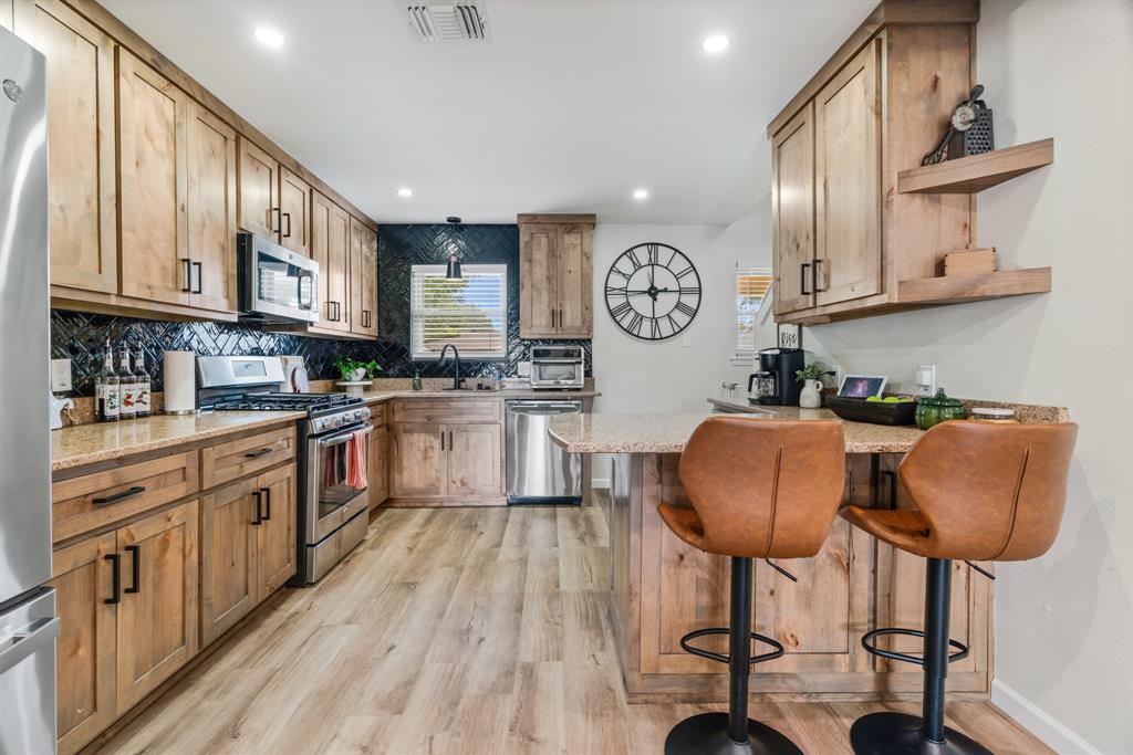 3276 Cleveland Street Paris, TX 75460 - Photo 14 of 31 a kitchen with stainless steel appliances granite countertop a cabinets a stove a sink and a refrigerator