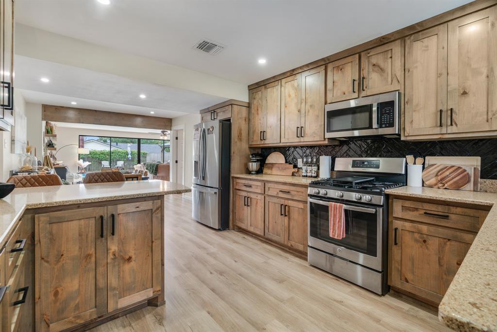 3276 Cleveland Street Paris, TX 75460 - Photo 27 of 31 a kitchen with stainless steel appliances granite countertop a stove a sink a refrigerator a microwave and cabinets