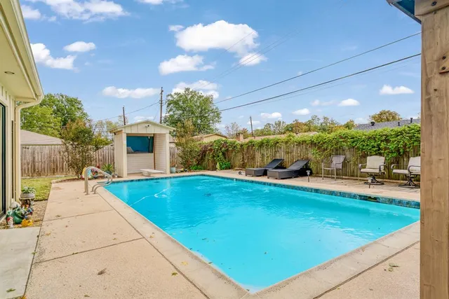 a view of house with swimming pool outdoor seating