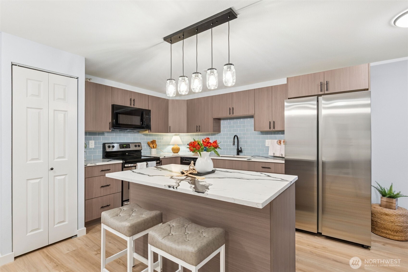 a kitchen with a refrigerator a sink cabinets and wooden floor