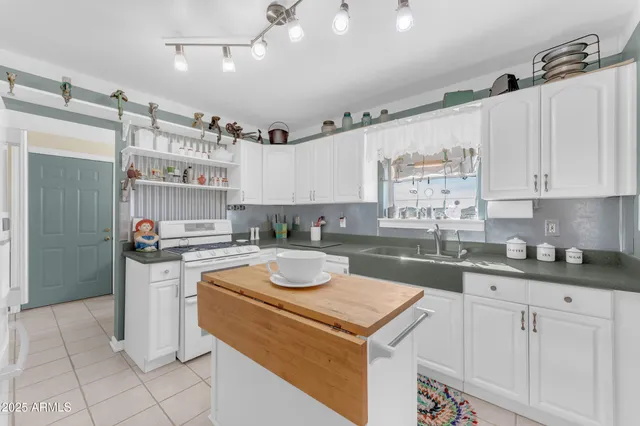 a kitchen with granite countertop a sink a stove and cabinets