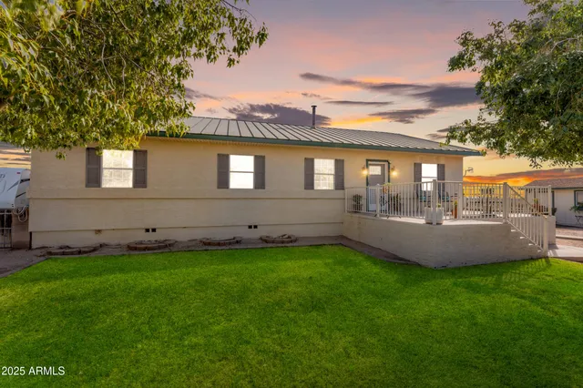a view of a patio with couches table and chairs potted plants and large tree