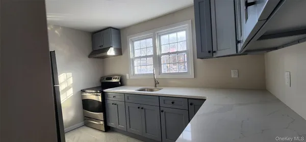 a kitchen with stainless steel appliances granite countertop a sink stove and white cabinets
