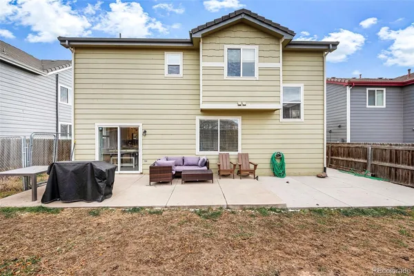 a view of a house with a patio and a yard