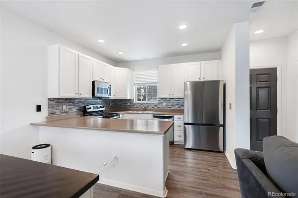 a kitchen with refrigerator cabinets and wooden floor