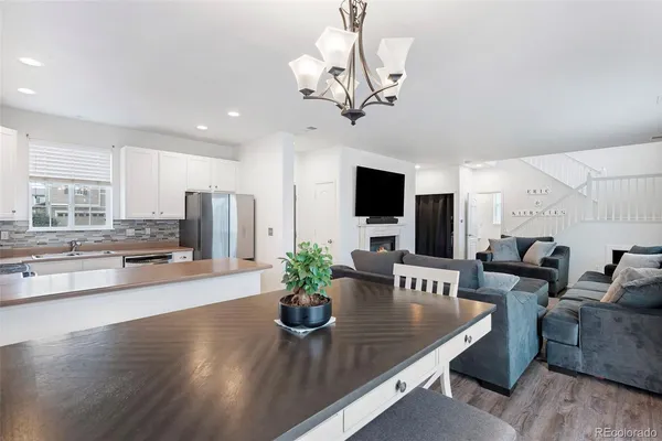 a living room with furniture dining table a flat screen tv and potted plant