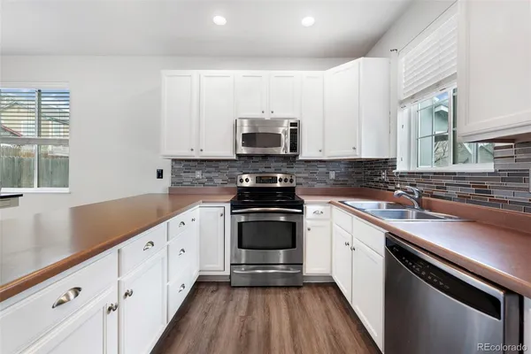 a kitchen with granite countertop a stove sink and cabinets