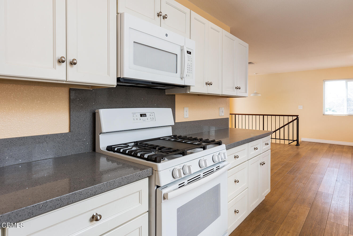 159-161 May Avenue Monrovia, CA 91016 - Photo 25 of 33 a kitchen with granite countertop white cabinets stove and wooden floor