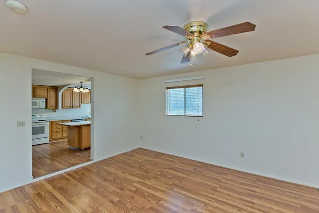 a view of an empty room with window and wooden floor