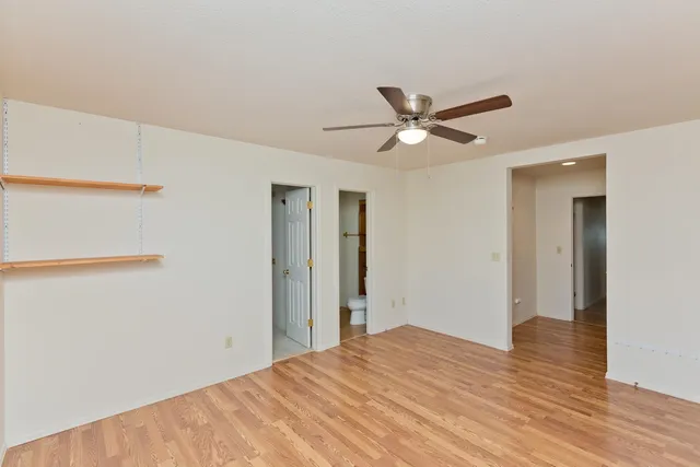 a room that has a bed and a ceiling fan