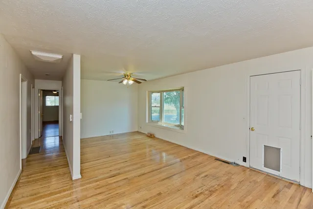 a view of empty room with wooden floor