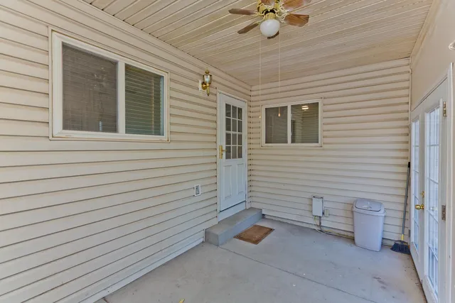 a view of a patio with a table and chairs and a ceiling fan