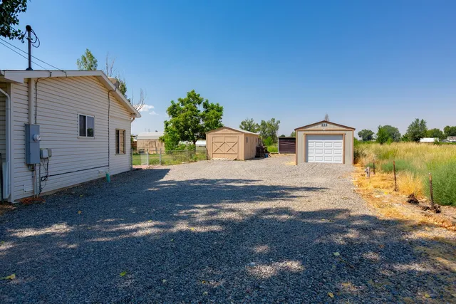 a view of a house with backyard and a tree