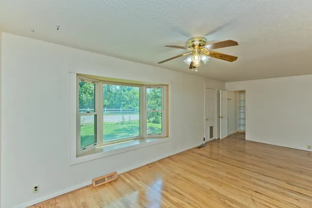 a view of a room with a ceiling fan and a window
