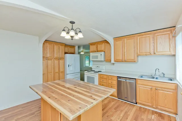 a kitchen with stainless steel appliances granite countertop a sink cabinets and wooden floor