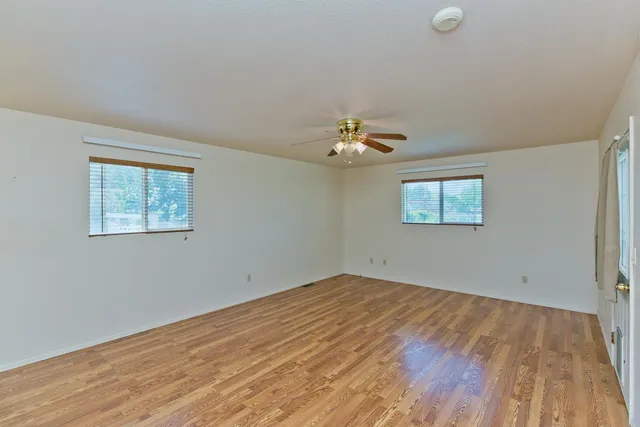 a view of empty room with wooden floor