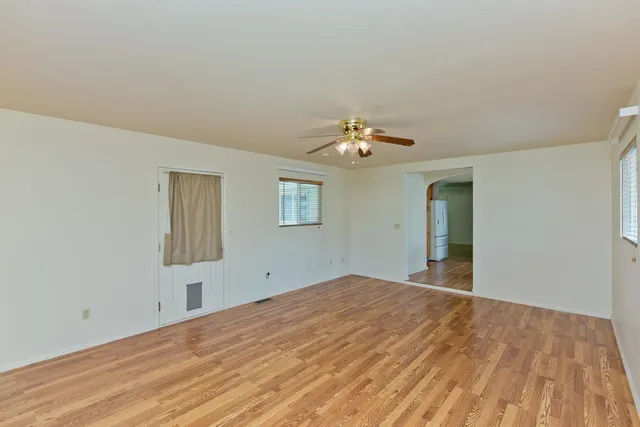 a view of empty room with window and chandelier fan