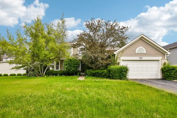 a front view of a house with yard and green space
