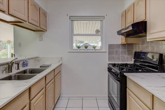 a kitchen with stainless steel appliances granite countertop a sink stove and cabinets