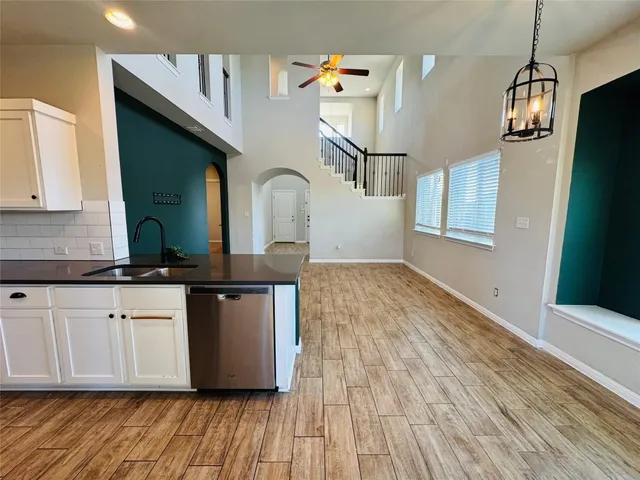 a kitchen with stainless steel appliances granite countertop a sink a microwave cabinets and wooden floor