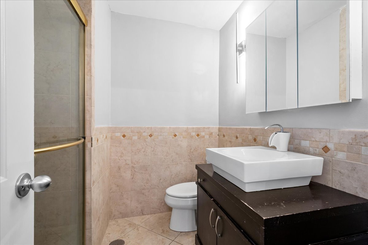 5701 North Sheridan Road, Unit 27M Chicago, IL 60660 - Photo 12 of 20 a bathroom with a sink a toilet and a mirror