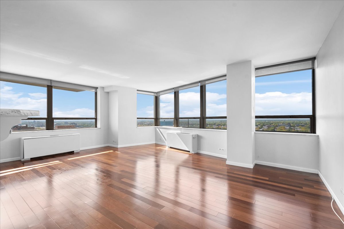 5701 North Sheridan Road, Unit 27M Chicago, IL 60660 - Photo 2 of 20 a view of an empty room with wooden floor and a window