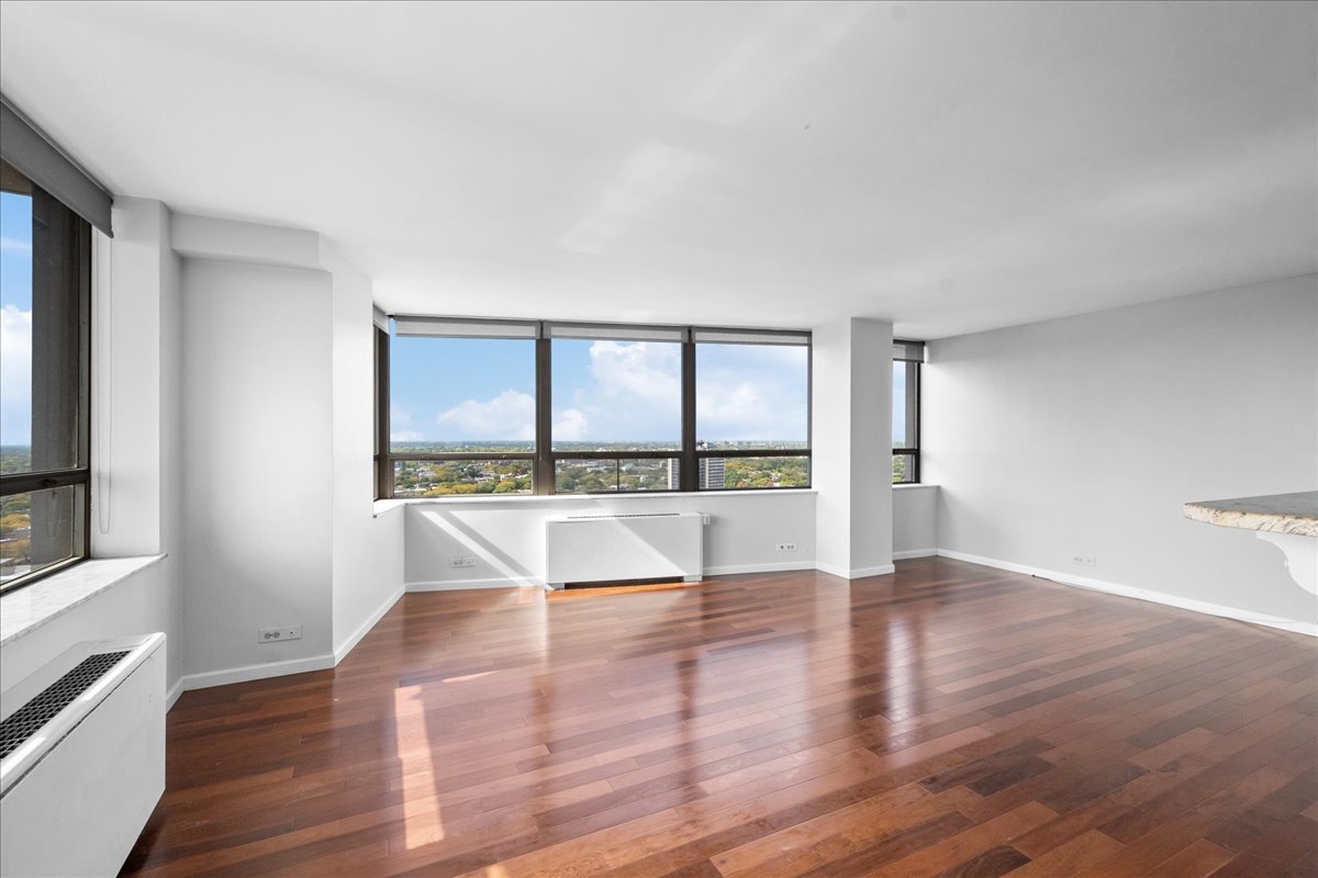 5701 North Sheridan Road, Unit 27M Chicago, IL 60660 - Photo 5 of 20 a view of an empty room with wooden floor and a window