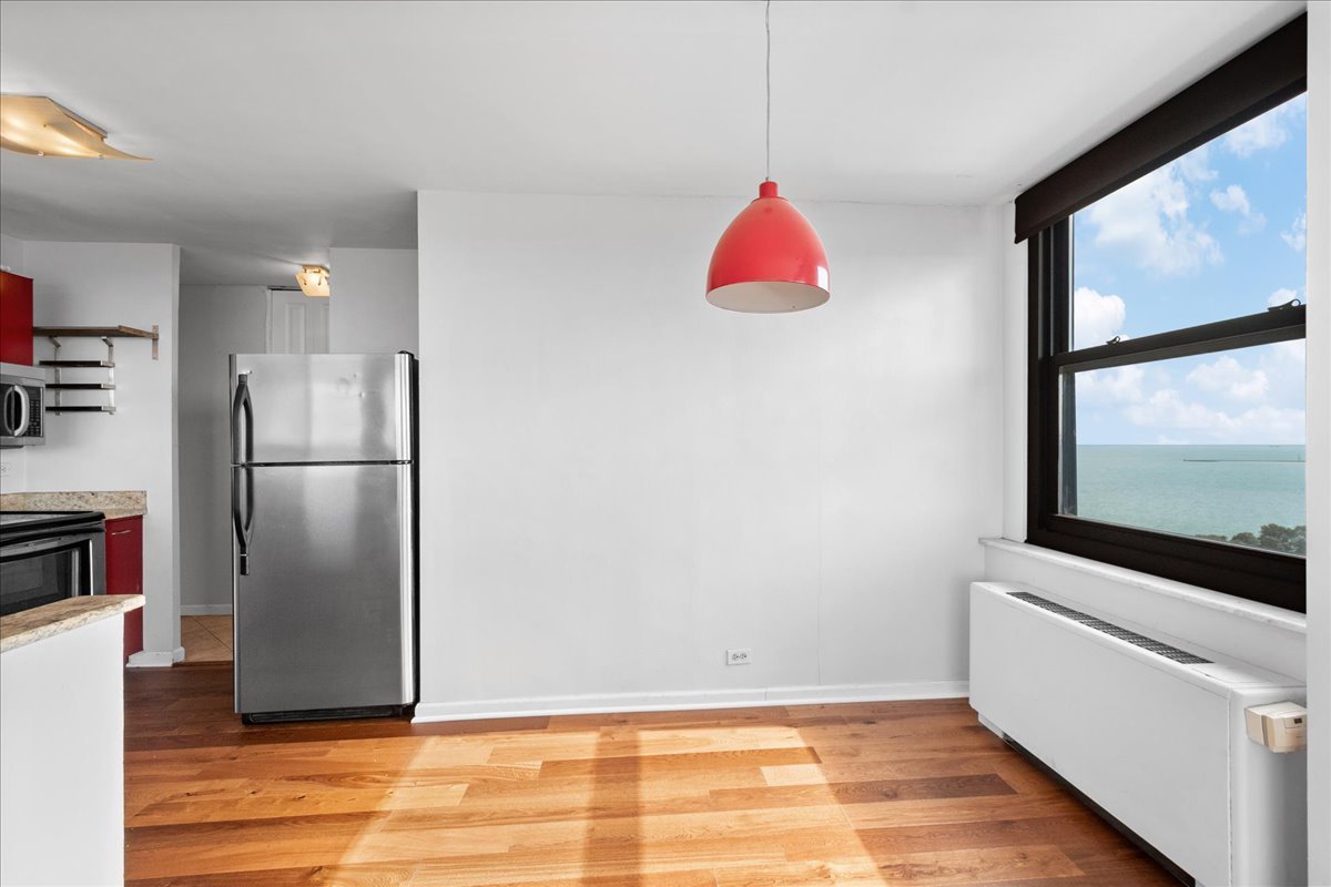 5701 North Sheridan Road, Unit 27M Chicago, IL 60660 - Photo 6 of 20 a view of a livingroom with wooden floor and a kitchen space