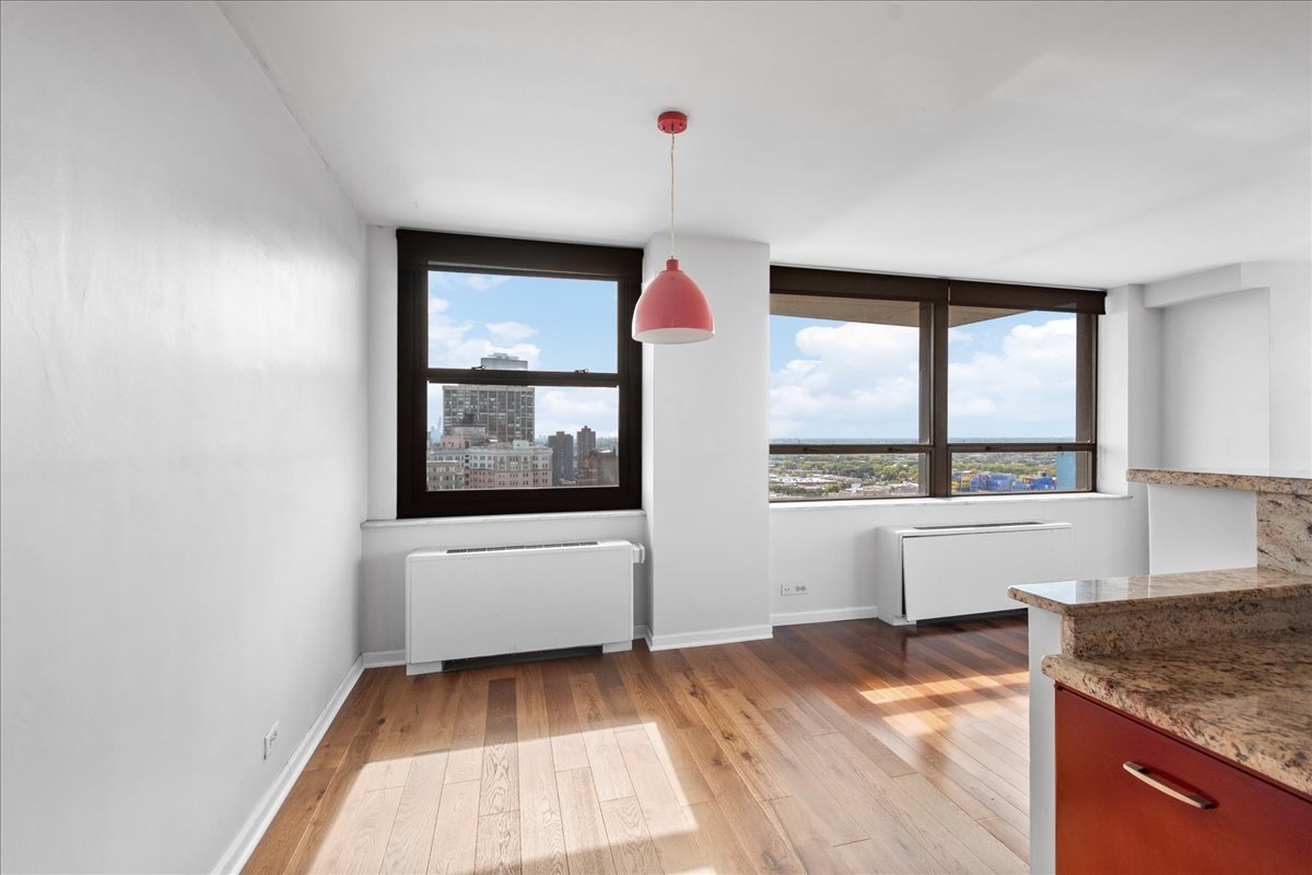 5701 North Sheridan Road, Unit 27M Chicago, IL 60660 - Photo 7 of 20 a view of a kitchen with kitchen island a sink wooden floor and window