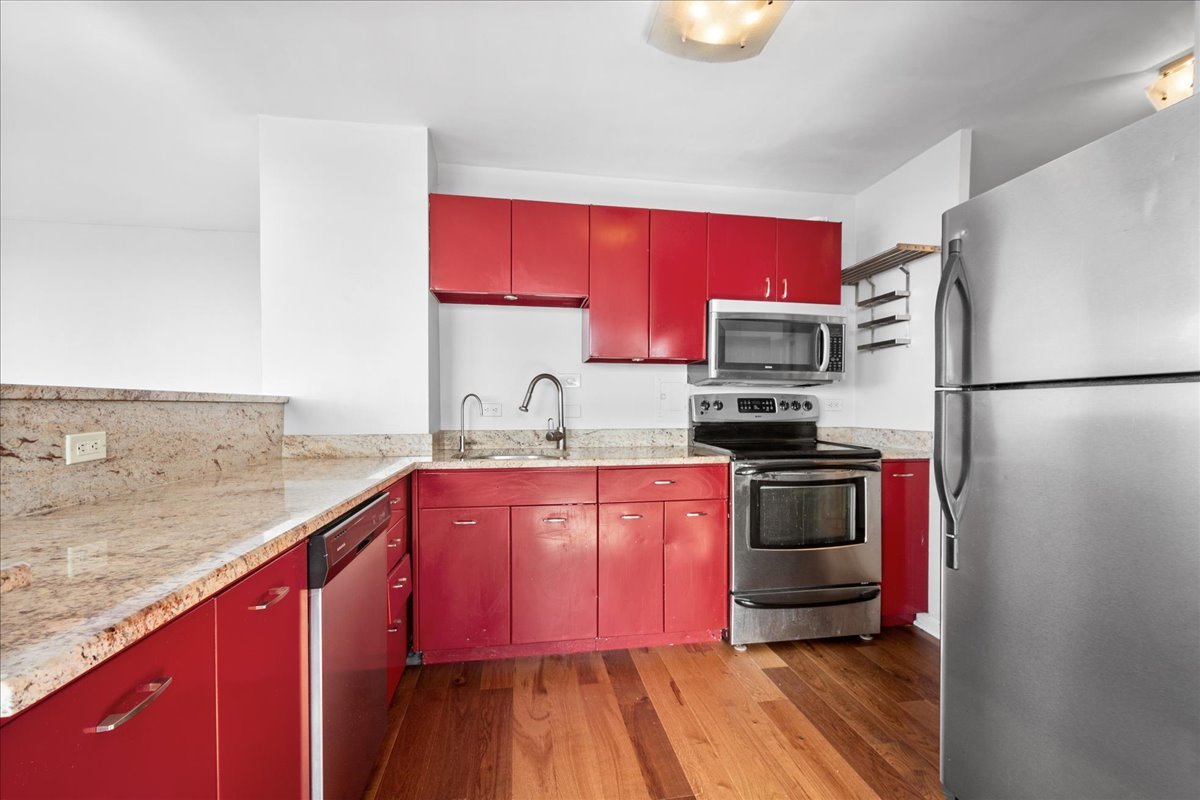 5701 North Sheridan Road, Unit 27M Chicago, IL 60660 - Photo 8 of 20 a kitchen with granite countertop a refrigerator stove top oven and sink