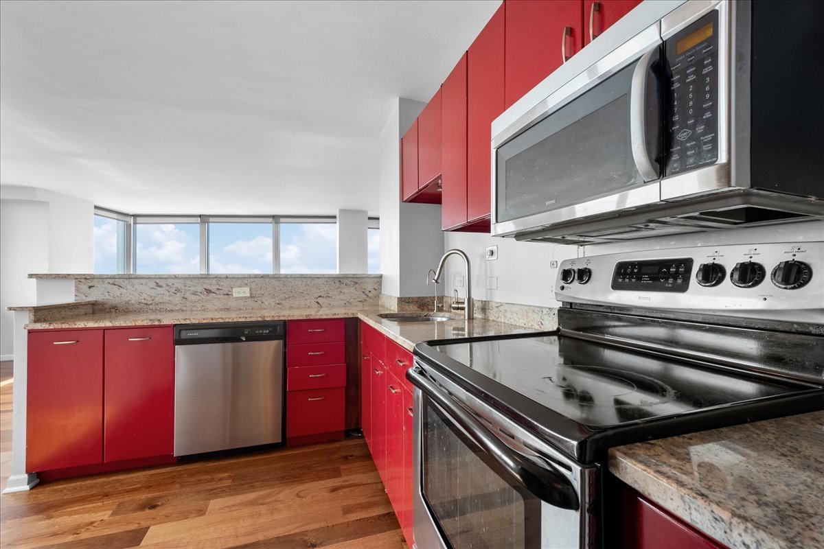 5701 North Sheridan Road, Unit 27M Chicago, IL 60660 - Photo 9 of 20 a kitchen with a stove and a microwave