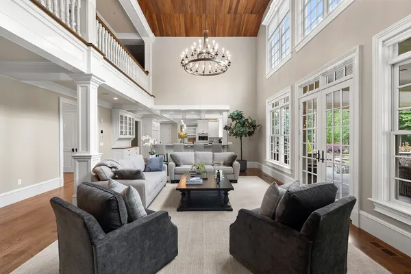a living room with furniture a chandelier and a large window