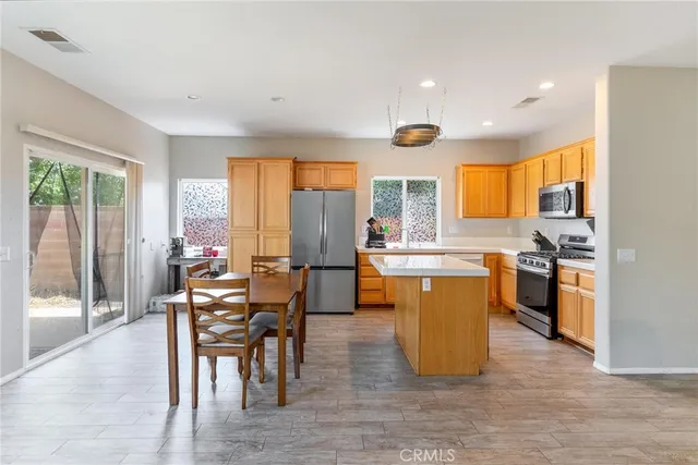 a kitchen with a table chairs refrigerator and cabinets